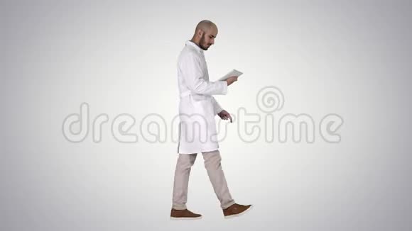 医生在梯度背景下检查他的平板电脑视频的预览图