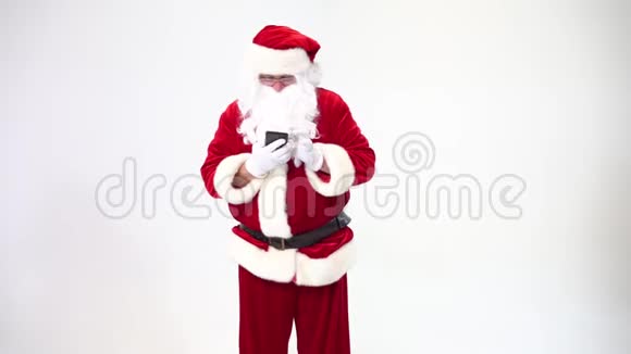 圣诞老人在白色背景下用黑色手机写短信并在上面交谈视频的预览图