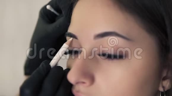 专业美容师为年轻女性在美容院做永久性眉毛化妆手术做准备绘制视频的预览图