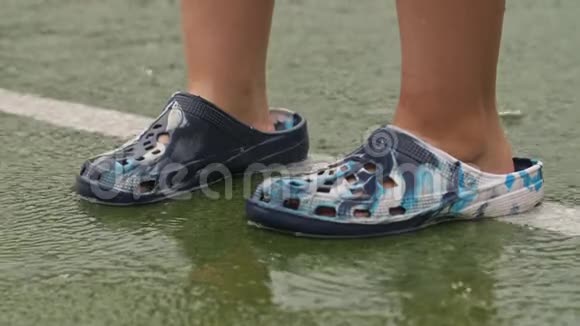 在雨中穿着橡胶拖鞋的人视频的预览图