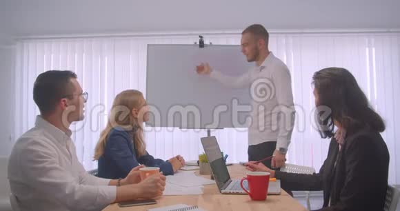 四个大联盟在办公室室内开会的肖像商人在白板上写字视频的预览图