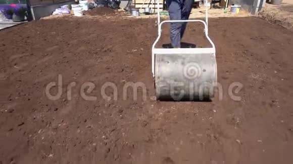 工人用土辊在花园辛勤工作向后移动视频的预览图