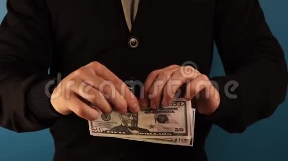 一个穿小丑衣服的人在蓝色的背景上撕下一大笔钱视频的预览图