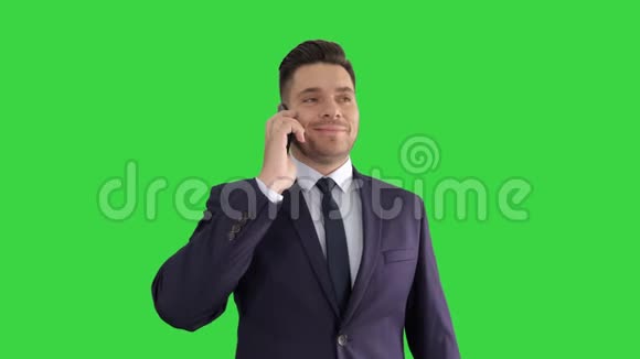 微笑的年轻商人有一个电话与他的手机在绿色屏幕Chroma键视频的预览图