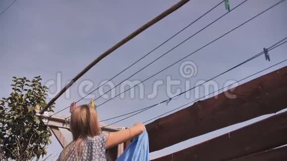 一个年轻的女人在夏天晾衣服视频的预览图