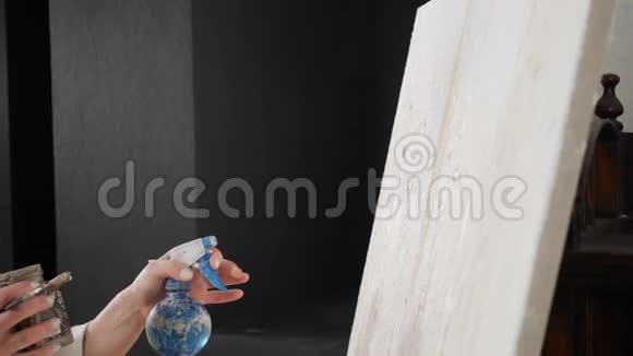 女艺术家在艺术工作室的白色画布上用画笔和滋润的水画慢动作视频的预览图