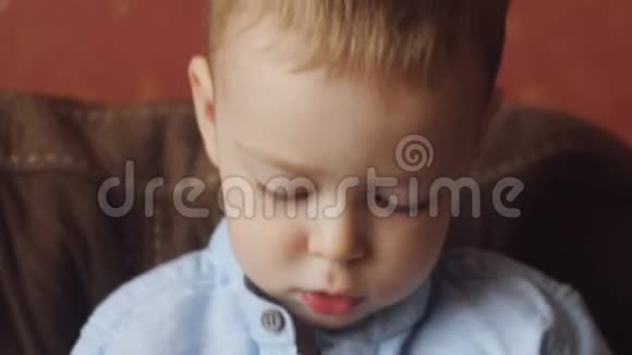 小男孩坐在沙发上玩玩具的肖像视频的预览图