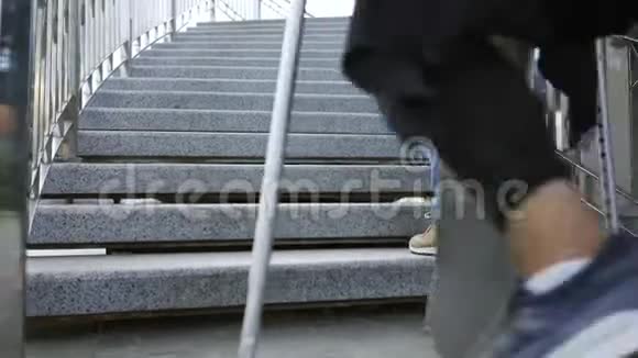 一条腿拄着拐杖滑板的年轻人爬楼梯比他的朋友快残疾人的积极生活视频的预览图