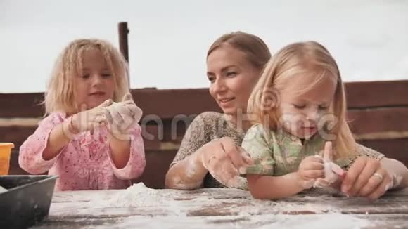 两个女儿用手在妈妈旁边揉面团自制面包烘焙视频的预览图