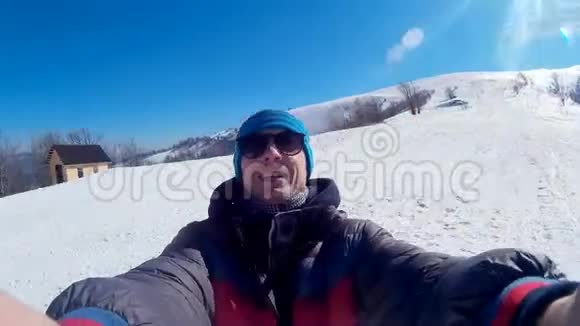 年轻快乐的家伙在雪山上自拍背景是一个令人惊叹的冬季景观视频的预览图