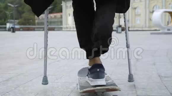 未识别男子单腿拐杖骑在滑板户外残疾人的积极生活他没有视频的预览图