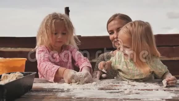 两个女儿用手在妈妈旁边揉面团自制面包烘焙视频的预览图