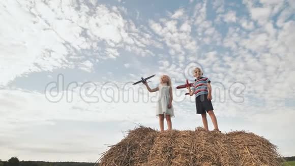 孩子们发动飞机站在一堆稻草上视频的预览图