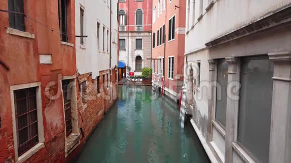 意大利威尼斯2019年5月非常狭窄的运河街道蓝色的水两侧未识别的砖建筑慢慢视频的预览图