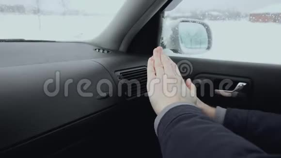 在冬天的白天车里的人用空调取暖器取暖一个人冻在外面视频的预览图