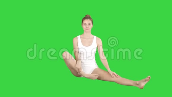 可爱的健身女性锻炼瑜伽坐在莲花的姿势和微笑后在绿色的屏幕色度键视频的预览图