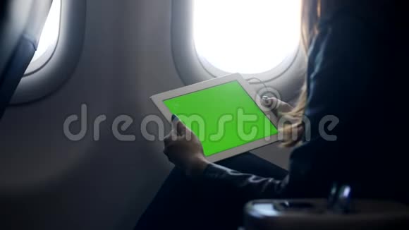 女人坐在飞机上听着耳机里最喜欢的歌在飞行中娱乐视频的预览图