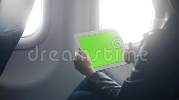 女人在现代平板电脑上工作在飞机上讲话视频的预览图