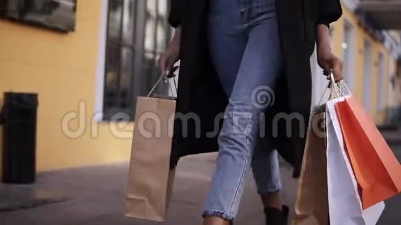 每天穿着时髦的黑色外套和牛仔裤的女人腿都会失去每天大购物后都会拿着彩色购物袋视频的预览图