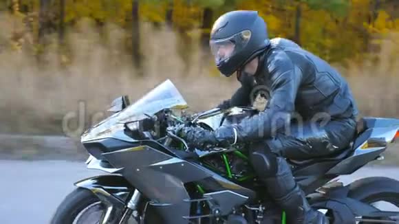 摩托车手在乡村公路上驾驶摩托车在旅途中开车的人戴头盔的年轻人骑得很快视频的预览图