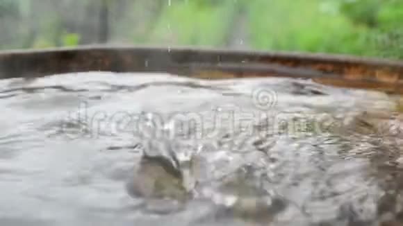 雨水从屋顶溅落到金属桶里视频的预览图