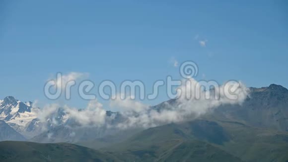 高地的白天时间流逝在夏天阳光明媚的日子里有雪山峰的天际线天气变化的概念视频的预览图