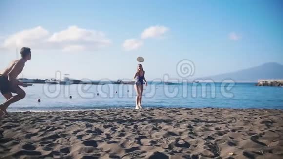 一个年轻人和他的女朋友在海滩上玩飞盘想抓住圆盘掉在沙子上视频的预览图