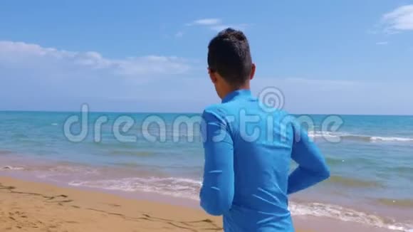 在阳光明媚的日子里运动员沿着海岸慢跑在海边的户外慢跑理念健康积极的生活方式视频的预览图