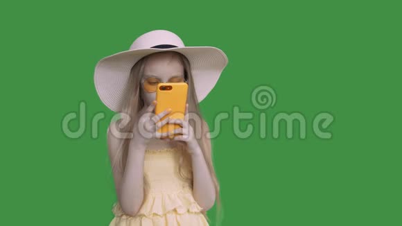 十几岁的女孩戴着夏天的帽子和衣服正在浏览电话和思考阿尔法频道视频的预览图