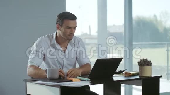 在笔记本电脑工作的商人冷静的人在工作场所做笔记视频的预览图