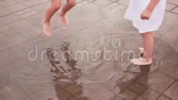 孩子们在城市街上的水坑里跳着玩视频的预览图