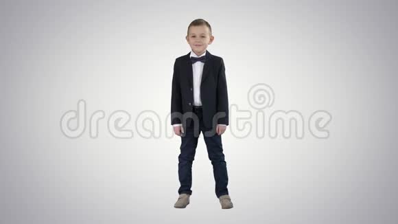 穿着正式衣服的微笑的小男孩站在梯度背景上视频的预览图