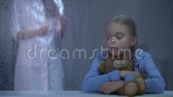 护士给生病的小女孩打针把泰迪熊抱在雨窗后面视频的预览图