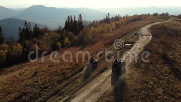 四辆自行车和越野车在山路上行驶晴朗的秋日空中观景视频的预览图