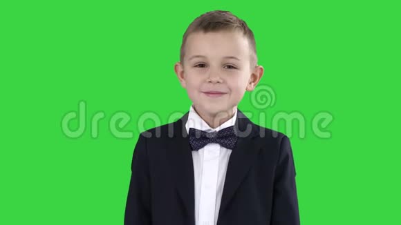 微笑的小男孩穿着正式的衣服站在绿色屏幕上Chroma键视频的预览图