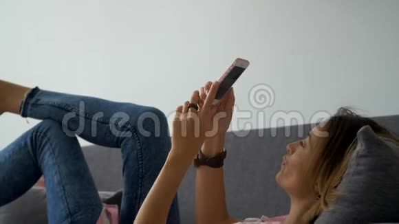 特写年轻开心笑的女人在手机上聊天笑着室内漂亮的女人用智能手机聊天视频的预览图