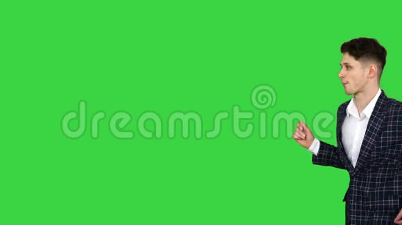 穿着正式服装的酷男在绿色屏幕上散步和跳舞Chroma键视频的预览图