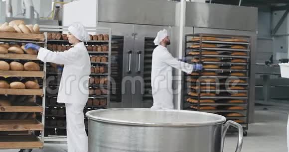 在一家面包店工作的一天准备面团的老面包师把面粉卸在容器里背景工人视频的预览图