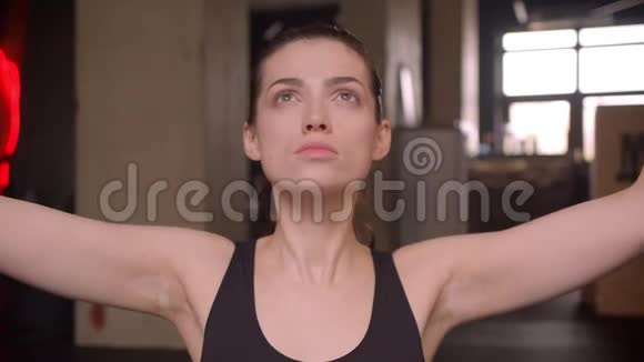 年轻有魅力运动员的特写镜头女性在室内健身房的摄像机前练习瑜伽视频的预览图