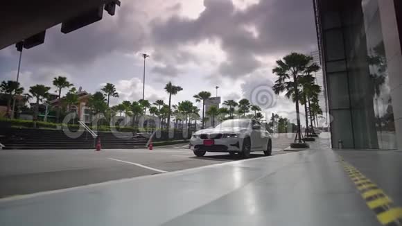 豪华的白色轿车驶上昂贵的酒店入口客人前来欣赏热带美景视频的预览图