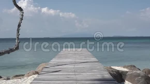 时光流逝复古和古老的木桥在海滩和海洋的中午与海滩海洋阳光岩石风和波浪周围视频的预览图