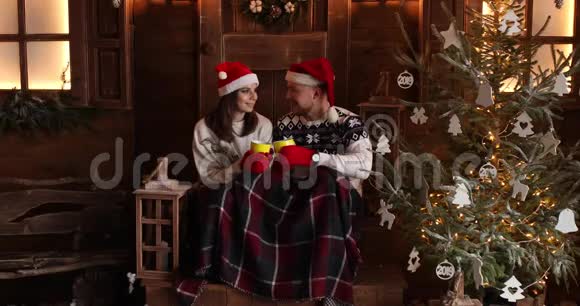 圣诞老人帽子里的圣诞浪漫一对快乐的情侣喝茶视频的预览图