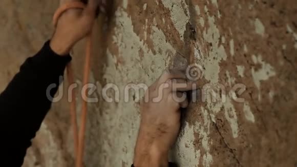 攀爬者攀爬墙和做保险的手的特写视频的预览图