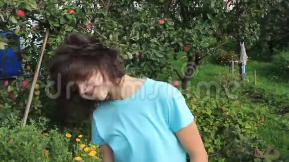 女孩在花园的背景上展示她的头发视频的预览图