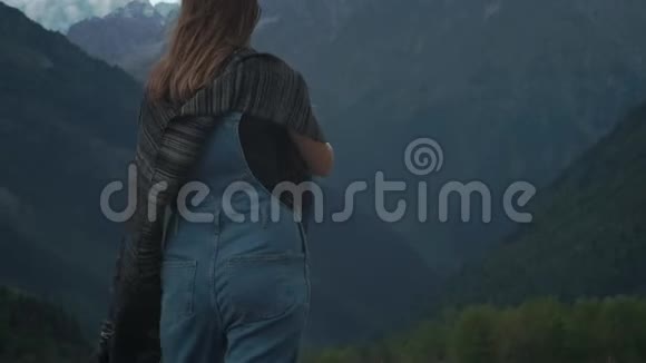 年轻迷人的女孩旅行者博客制作了一张大山的照片在智能手机上穿着暖和的衣服视频的预览图