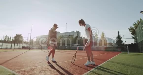 网球场上两位漂亮的女士准备网球比赛打手和开始比赛视频的预览图