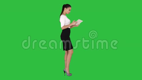 美丽的年轻成年女人在绿色屏幕上玩平板电脑游戏Chroma键视频的预览图