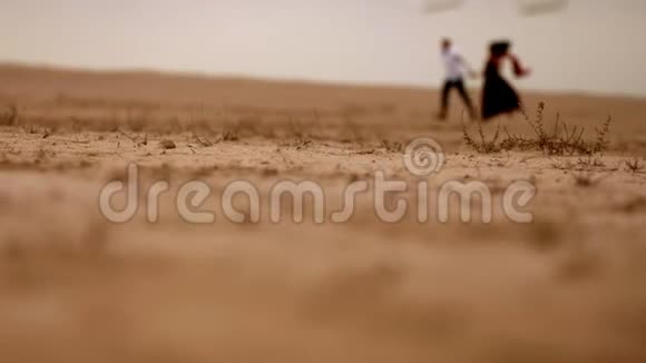 男人和女人在沙漠中奔跑视频的预览图