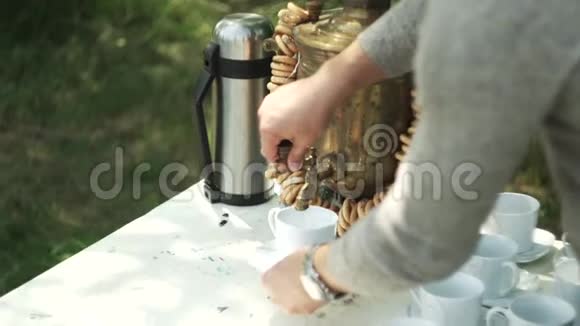 女人从萨莫瓦尔把沸水倒进杯子里视频的预览图