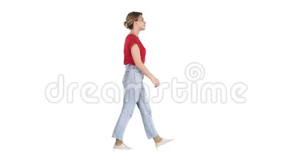 穿红色t恤牛仔裤和运动鞋的女人走在白色背景上视频的预览图
